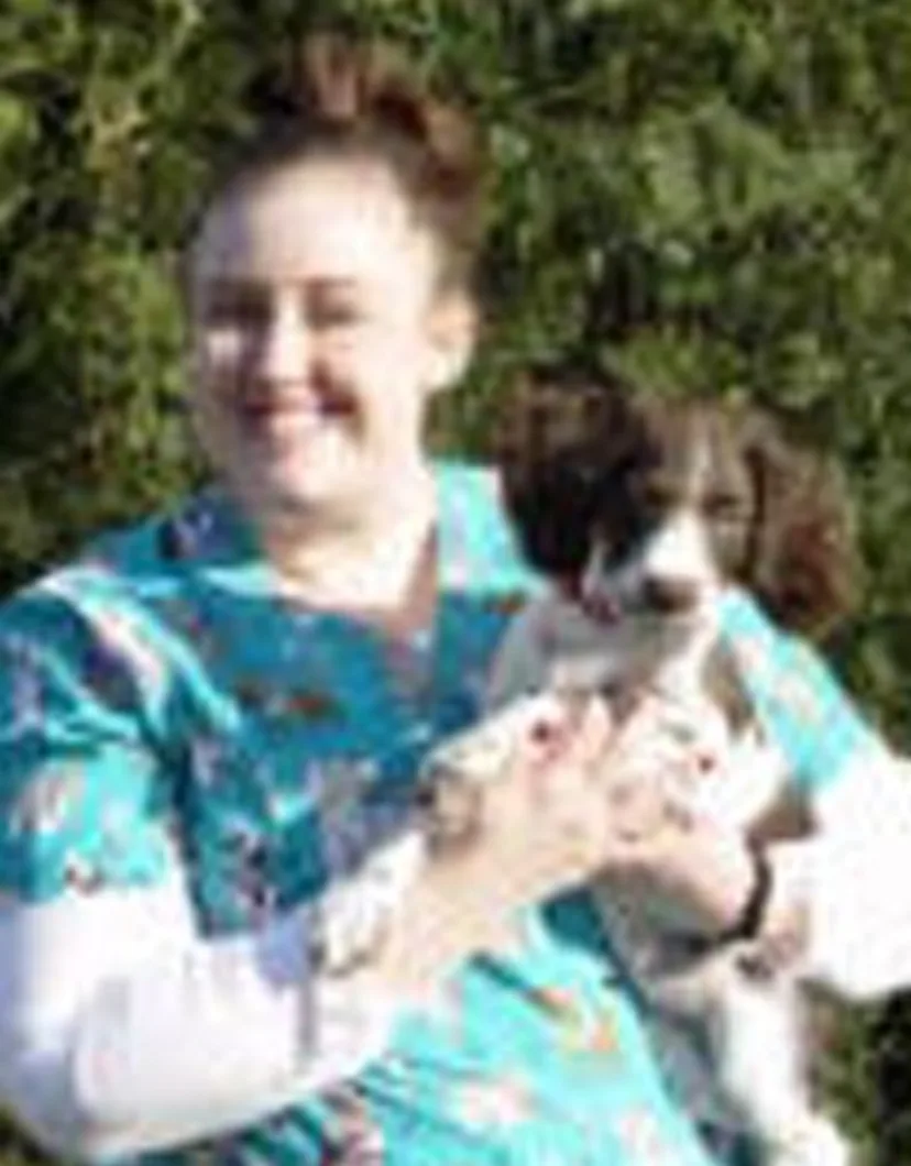 Jana's staff photo from Stillwater Veterinary Clinic posing with her little poodle outside.
